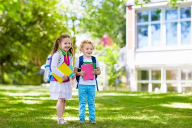 Çocuklar okula geri döner. Yaz tatilinden sonraki yıl yeni bir okula başlıyorum. İlk okul gününde sırt çantası ve kitapları olan kız ve erkek. Dersin başında. Anaokulu ve anaokulu çocukları için eğitim.