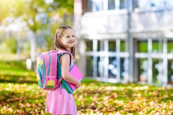 Çocuk okula geri dönüyor. Yaz tatilinden sonraki yıl yeni bir okula başlıyorum. İlk okul gününde sırt çantası ve kitapları olan küçük bir kız. Dersin başında. Anaokulu ve anaokulu çocukları için eğitim.
