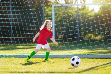 Çocuklar dışarıda futbol oynarlar. Portekiz takım taraftarları. Çocuklar futbol maçında gol attılar. Portekiz formalı ve krampon kramponlu küçük kız. Futbol sahası. Oyuncu için spor eğitimi.
