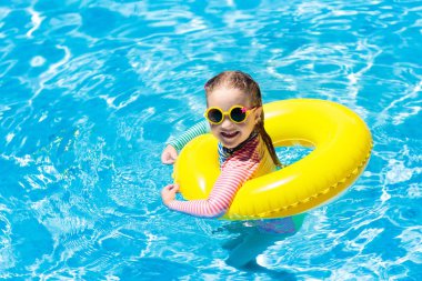 Çocuk yüzme havuzu güneş gözlüklü. Şişme yüzüğü küçük kız. Renkli float evlat. Çocuklar yüzmek ve tropikal resort açık yüzme havuzunda dalış öğrenin. Güneş koruma ve göz giymek. Su eğlenceli.