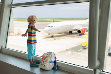Havaalanı'nda çocuklar. Çocuk uçağa bak. Seyahat ve çocuk ile uçan. Aile kalkış kapısı. Tatil ve seyahat genç çocukla. Terminal uçuş önce küçük bir çocuk. Çocuklar uçak.