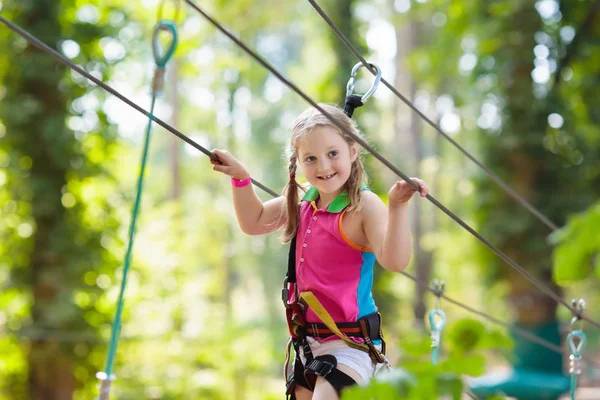 森のアドベンチャーパークの子供 子供たちは高いロープトレイルに登る 敏捷性と子供のための屋外遊園地を登る 屋外で遊んでいる女の子 ロープの道を持つ学校の庭の遊び場 — ストック写真