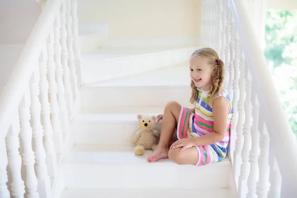 小孩在白宫里走楼梯小女孩在阳光灿烂的楼梯上玩耍 家人搬入新家 孩子们爬上了现代楼梯的台阶 大堂或客厅的内部 幼儿的家居安全 — 图库照片