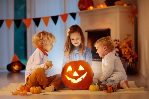 Dzieci Rzeźbienie Dyni Halloween Domu Siedzi Obok Kominka Salonie Ozdobione — Zdjęcie stockowe