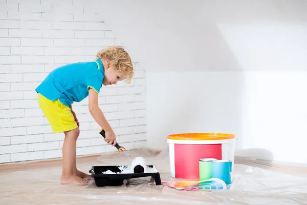 Kids painting attic wall. Home improvement and renovation. Child applying white paint on brick walls in bedroom. Renovating sky parlor with slanted walls. Family moving into new house. — Stock Image Kids Painting Attic Wall Home Improvement Renovation Child Applying White Stock Picture