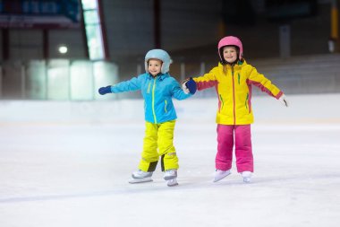 Kapalı buz pistinde paten çocuklar. Çocuklar ve aile sağlıklı kış sporları. Erkek ve kız ile buz pateni. Okul eğitim genç çocuk için spor sonra etkin. Kar eğlenceli aktivite soğuk hava tarafından.