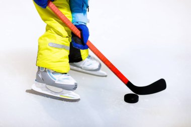 Paten kapalı pistinde buz hokeyi oynayan çocuk. Çocuklar için sağlıklı kış sporları. Hokey sopaları puck isabet çocuk. Çocuk buz pateni. Spor okuldan sonra eğitim üzerinde küçük bir çocuk. Kar ve buz eğlenceli.