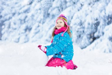 Karlı kış parkında kardan adam yapan bir çocuk. Çocuklar karda oynar. Kar yağdıktan sonra kış bahçesinde kardan adam yapan renkli ceketli ve şapkalı küçük kız. Soğuk kış gününde açık hava eğlencesi.