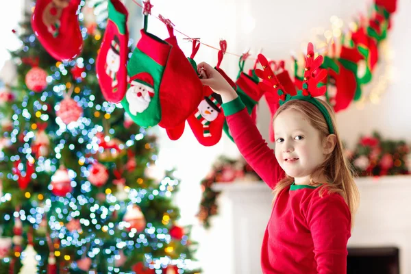 クリスマス プレゼントを開ける子供たち 冬の朝 アドベント カレンダーでお菓子とギフトをお探しの子 子供と家族のためのクリスマス ツリーを装飾しました クリスマス パジャマ少女 — ストック写真