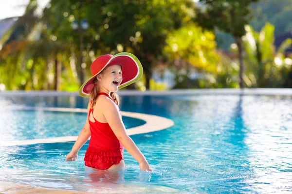 スイミングプールの子供 子供連れの家族のための熱帯休暇 エキゾチックな島のリゾートの屋外プールで遊んで赤い水着とスイカの太陽の帽子を身に着けている女の子 子供たちのための水と水泳 — ストック写真