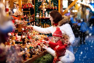 Anne ve çocuk, geleneksel Alman Xmas caddesi pazarında el yapımı cam Noel ağacı süslerini izliyorlar. Karlı bir günde Noel hediyesi almak için çocuk alışverişi yapan bir aile..
