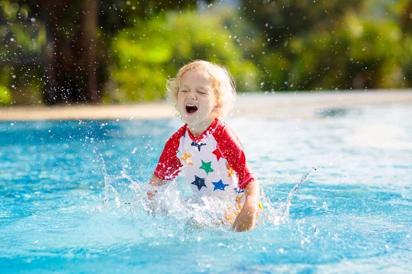 子供たちはプールで遊んでいる 子供たちと夏休み 熱帯の島のリゾートでエキゾチックな休日の間に水に飛び込む小さな男の子 子供たちは泳ぐ 未就学児のためのアクティブな屋外スポーツ — ストック写真