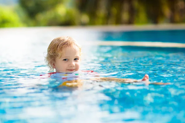 子供たちはプールで遊んでいる 子供たちと夏休み 熱帯の島のリゾートでエキゾチックな休日の間に水に飛び込む小さな男の子 子供たちは泳ぐ 未就学児のためのアクティブな屋外スポーツ — ストック写真