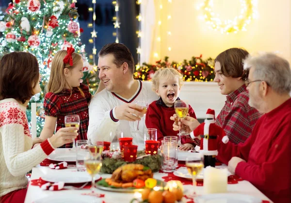 有孩子的家庭在壁炉边吃圣诞大餐 装饰着圣诞树 祖父母和孩子们正在享用节日大餐 寒假庆祝和食物 孩子们打开礼物和礼物 — 图库照片