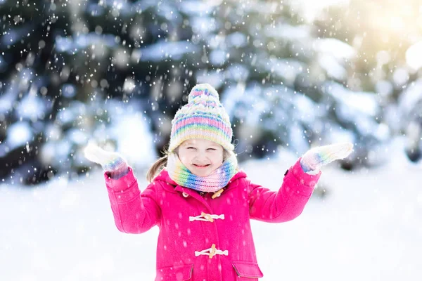 孩子在冬天玩雪 圣诞节时 小女孩穿着五颜六色的夹克 戴着针织帽子 在冬天公园里捉雪花 孩子们在白雪皑皑的森林里玩耍和跳跃 雪球为孩子们而战 — 图库照片