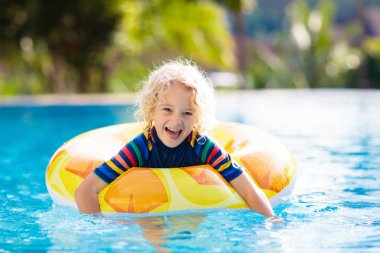 Şişme oyuncak yüzük float Yüzme Havuzu ile çocuk. Küçük çocuk öğrenme yüzme ve dalış tropik resort açık yüzme havuzunda. Çocuklarla yüzmek. Çocuklar için sağlıklı spor aktivitesi. Su eğlenceli.