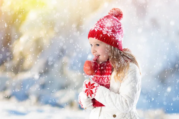 孩子们在冬天的集市上吃糖果苹果 孩子们在雪地里的圣诞市场上吃太妃糖苹果 外面下雪天很好玩 圣诞节期间的家庭假期 孩子们在户外玩耍 孩子们的冬季时尚 — 图库照片