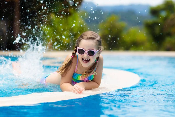 子供たちはプールで遊んでいる 子供たちと夏休み 熱帯の島のリゾートでエキゾチックな休日の間に水に飛び込む小さな女の子 子供たちは泳ぐ 未就学児のためのアクティブな屋外スポーツ — ストック写真