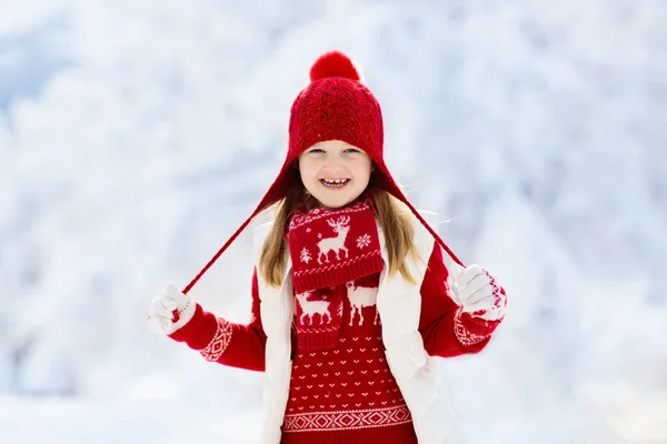 크리스마스 때빨간 모자를 속에서 노는아이 야외에서의 아이들은 크리스마스 이브에 눈덮인 — 스톡 사진