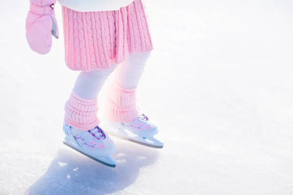 stock image Child skating on natural ice on sunny winter day. Kids with skates. Little girl skating on frozen lake in snowy park. Snow and winter fun. Healthy outdoor activity for children. Kid on ice rink.