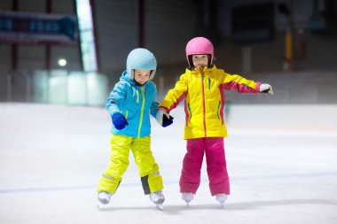 Kapalı buz pistinde paten çocuklar. Çocuklar ve aile sağlıklı kış sporları. Erkek ve kız ile buz pateni. Okul eğitim genç çocuk için spor sonra etkin. Kar eğlenceli aktivite soğuk hava tarafından.