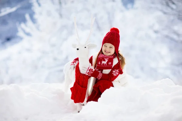 圣诞节假期 孩子们在雪地里玩驯鹿 冬天户外的乐趣 圣诞节前夕 孩子们在雪地公园玩耍 穿着针织毛衣 围巾和带圣诞装饰品的手套的小女孩 — 图库照片