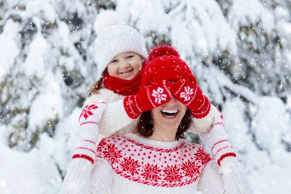 在家庭圣诞假期 戴着针织冬季帽子的母亲和孩子们在雪地里玩耍 给妈妈和孩子的手工羊毛帽子和围巾 给孩子们织毛衣针织外套 雪地公园里的妇女和小女孩 — 图库照片
