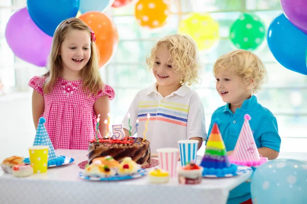 子供の誕生日パーティー カラフルなケーキの上のろうそくを吹きの子 虹旗バナー 風船で飾られた家 ファーム動物のテーマにお祝いします 小さな少年の祝う誕生日 パーティー フード — ストック写真