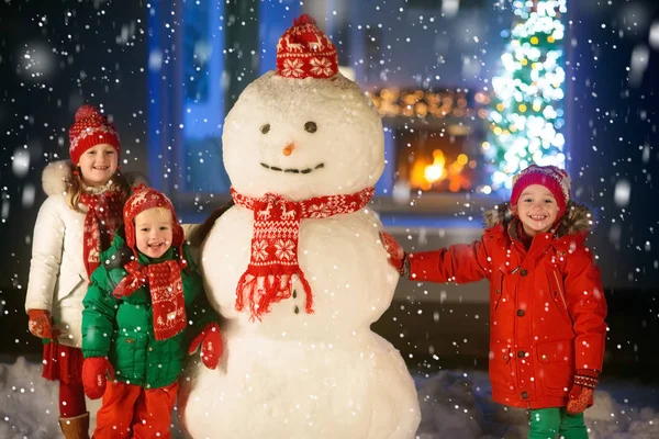 Děti Stavějí Sněhuláka Štědrý Den Děti Zasněženém Dvorku Vedle Okna — Stock fotografie