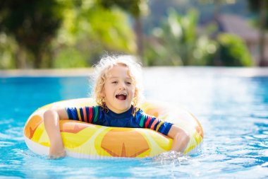 Şişme oyuncak yüzük float Yüzme Havuzu ile çocuk. Küçük çocuk öğrenme yüzme ve dalış tropik resort açık yüzme havuzunda. Çocuklarla yüzmek. Çocuklar için sağlıklı spor aktivitesi. Su eğlenceli.