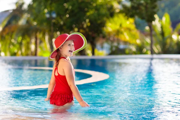 スイミングプールの子供 子供連れの家族のための熱帯休暇 エキゾチックな島のリゾートの屋外プールで遊んで赤い水着とスイカの太陽の帽子を身に着けている女の子 子供たちのための水と水泳 — ストック写真