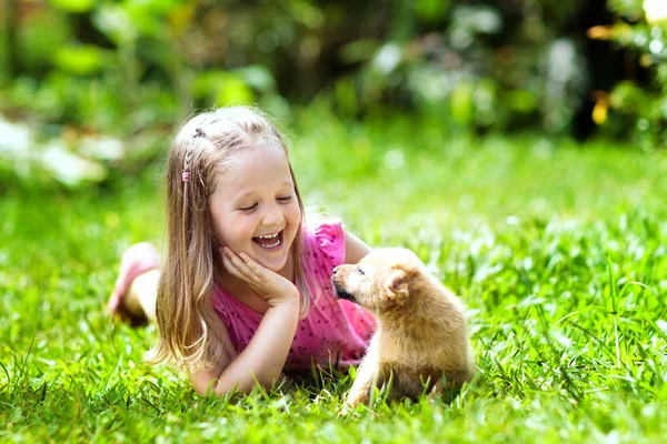 귀여운 강아지와 재생합니다 어린이 화창한 정원에서 강아지 강아지와 아이입니다 그리고 — 스톡 사진