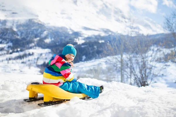 小女孩喜欢坐雪橇 孩子们滑行 Toddler的孩子骑着雪橇孩子们在外面雪地里玩耍 孩子们在阿尔卑斯山里滑雪橇 家庭圣诞假期的户外乐趣 — 图库照片