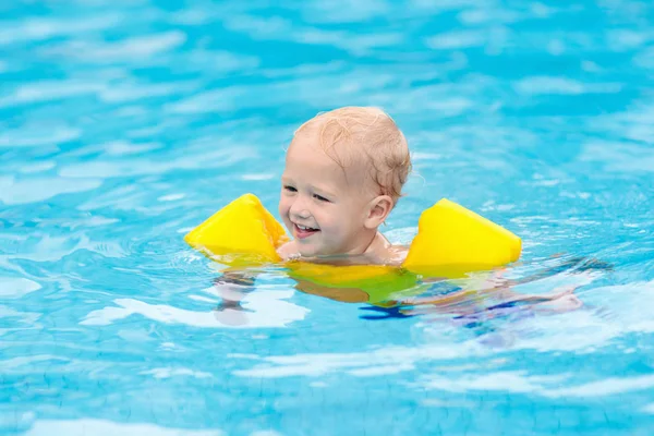 Baby in swimming pool. Kids swim.