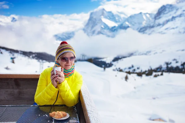 Женщина пьет кофе в горах после лыж . — стоковое фото