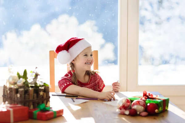 Un niño escribiendo una carta a Santa. Presente la lista de deseos . — Foto de Stock