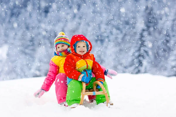 As crianças brincam na neve. Passeio de trenó de inverno para crianças — Fotografia de Stock