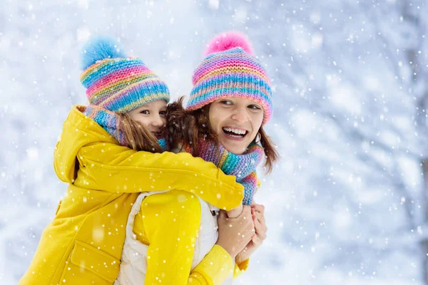 Mère et enfant en bonnets d'hiver tricotés dans la neige . — Photo