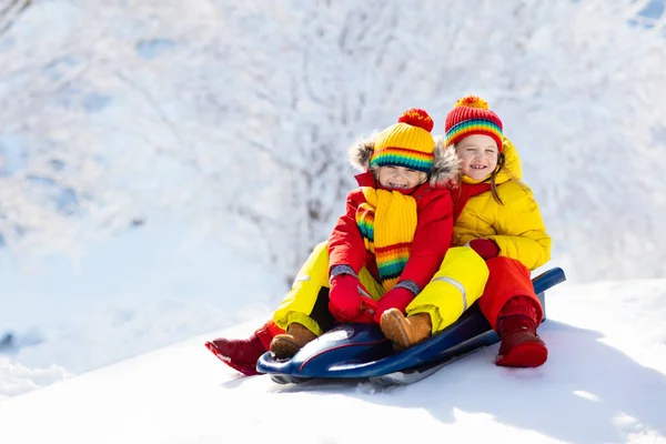 小女孩和男孩喜欢坐雪橇 孩子们滑行 Toddler的孩子骑着雪橇孩子们在外面雪地里玩耍 孩子们在雪地的公园里滑雪橇 家庭圣诞假期的户外乐趣 — 图库照片