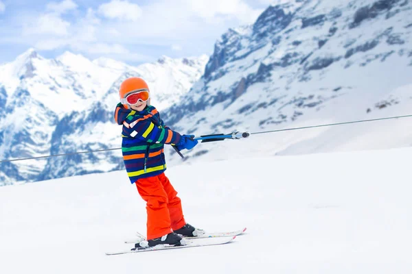 日当たりの良い雪の日に山に上りボタン スキー場のリフトの子 アルペン リゾートの冬スポーツの学校の子供たち 雪の中で家族の楽しみです 少しスキーヤー学習と斜面の運動 — ストック写真