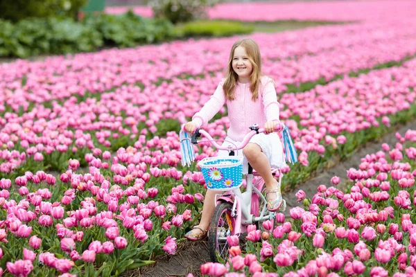 儿童骑自行车在郁金香花卉领域期间在荷兰的家庭春季假期 孩子骑着粉红色的郁金香骑车 在荷兰骑车的小女孩 欧洲旅行与孩子 儿童旅行 — 图库照片