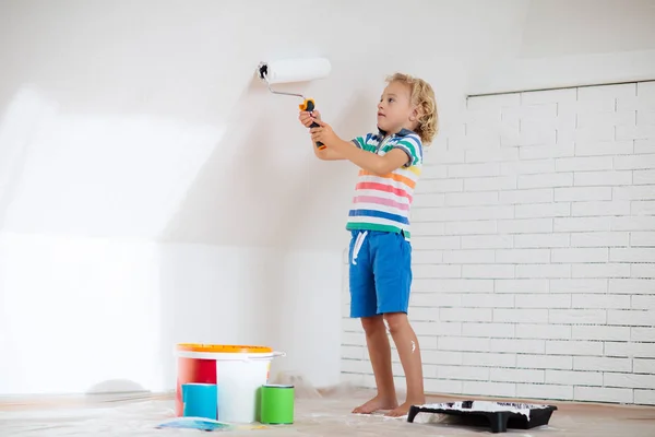 Kids painting attic wall. Home improvement and renovation. Child applying white paint on brick walls in bedroom. Renovating sky parlor with slanted walls. Family moving into new house. — Stock Image Kids Painting Attic Wall Home Improvement Renovation Child Applying White Royalty Free Stock Photos