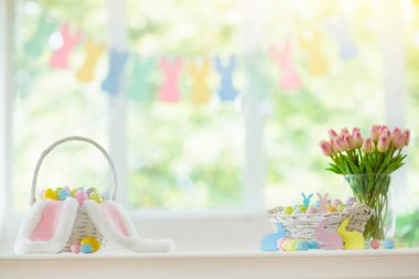 Paskalya ev dekorasyon. Renkli boyalı yumurta ve tavşan kulağı, Lale çiçek ve şenlikli Paskalya kutlaması evde için ahşap tavşan sepet. Çocuklar sepeti için Paskalya yortusu yumurta avlamak.