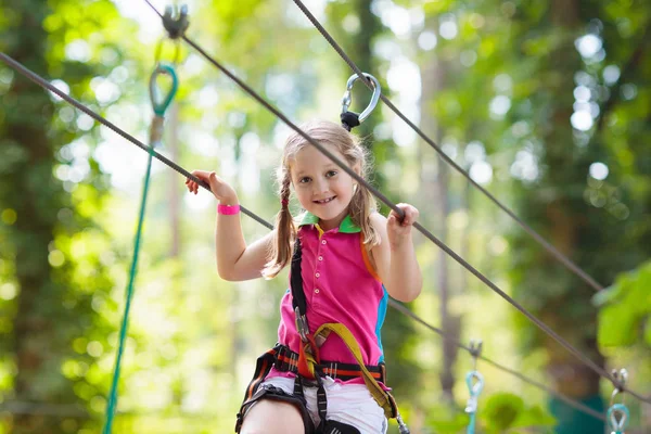 森のアドベンチャーパークの子供 子供たちは高いロープトレイルに登る 敏捷性と子供のための屋外遊園地を登る 屋外で遊んでいる女の子 ロープの道を持つ学校の庭の遊び場 — ストック写真
