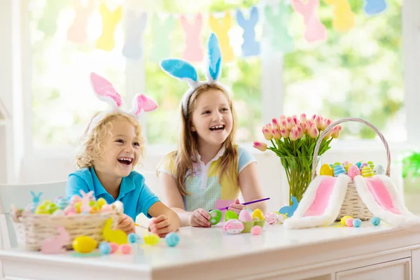子供たちはイースターの卵を染色します バニーの耳の子供たちは イースター ハントのカラフルな卵を染めます バスケット春の休日のお祝いのウサギと家の装飾 男の子と女の子を飾るホーム — ストック写真