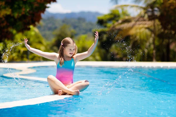 子供たちはプールで遊んでいる 子供たちと夏休み 熱帯の島のリゾートでエキゾチックな休日の間に水に飛び込む小さな女の子 子供たちは泳ぐ 未就学児のためのアクティブな屋外スポーツ — ストック写真