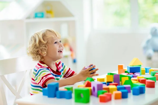 crianças brincando com tijolos e jogos educativos na sala do