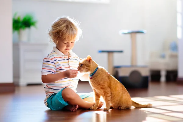 Bambino che gioca con il gatto a casa. Bambini e animali domestici . — Foto Stock