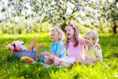 Bahar park aile pikniği. Çocuklar açık havada yemek
