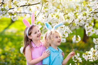 Paskalya yumurtası avı. Tavşan kulakları ve sepet çocuklarla.